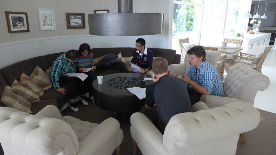 The five members of group discussing in a lounge area.