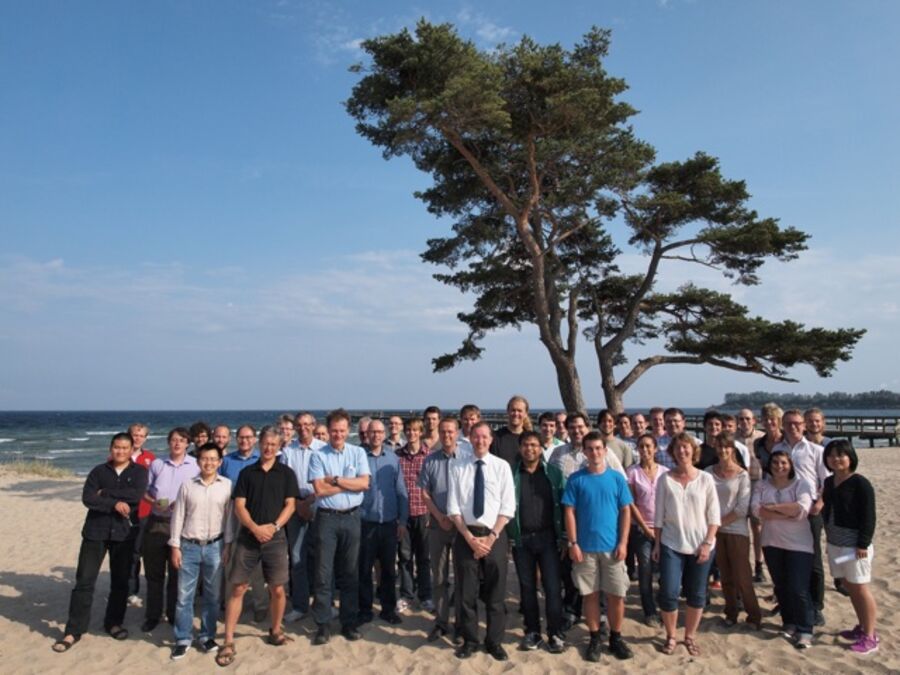 A group phots of the participants in front of a tree on the beach at Ystad Saltsjöbad